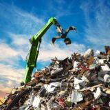 scrap monton de basura electronica en un basurero siendo recogido por una maquina